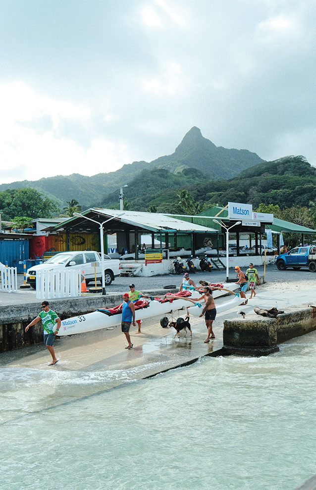 a group of people carrying kayaks on a beach