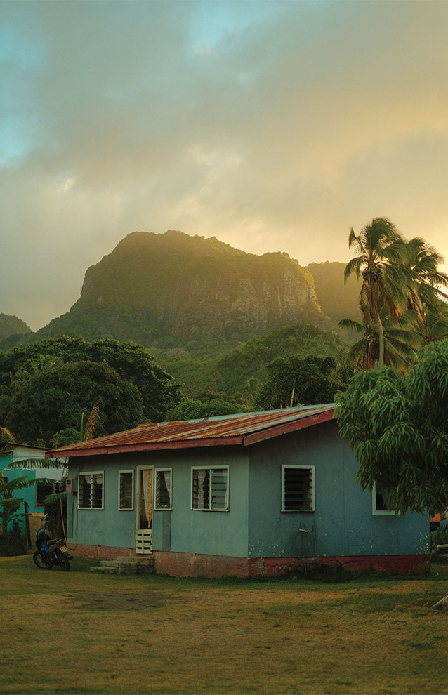 a house with trees and mountains in the background