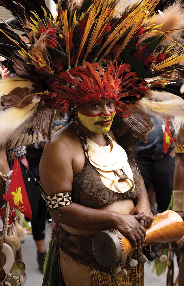 a person wearing traditional clothing, including a big feathered head piece