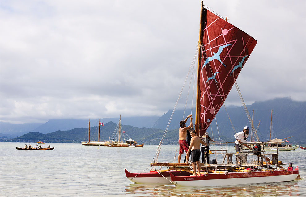 landscape of a boat with a group of people tending to the sails